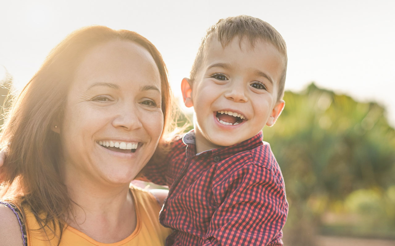 Mother and son smiling outside