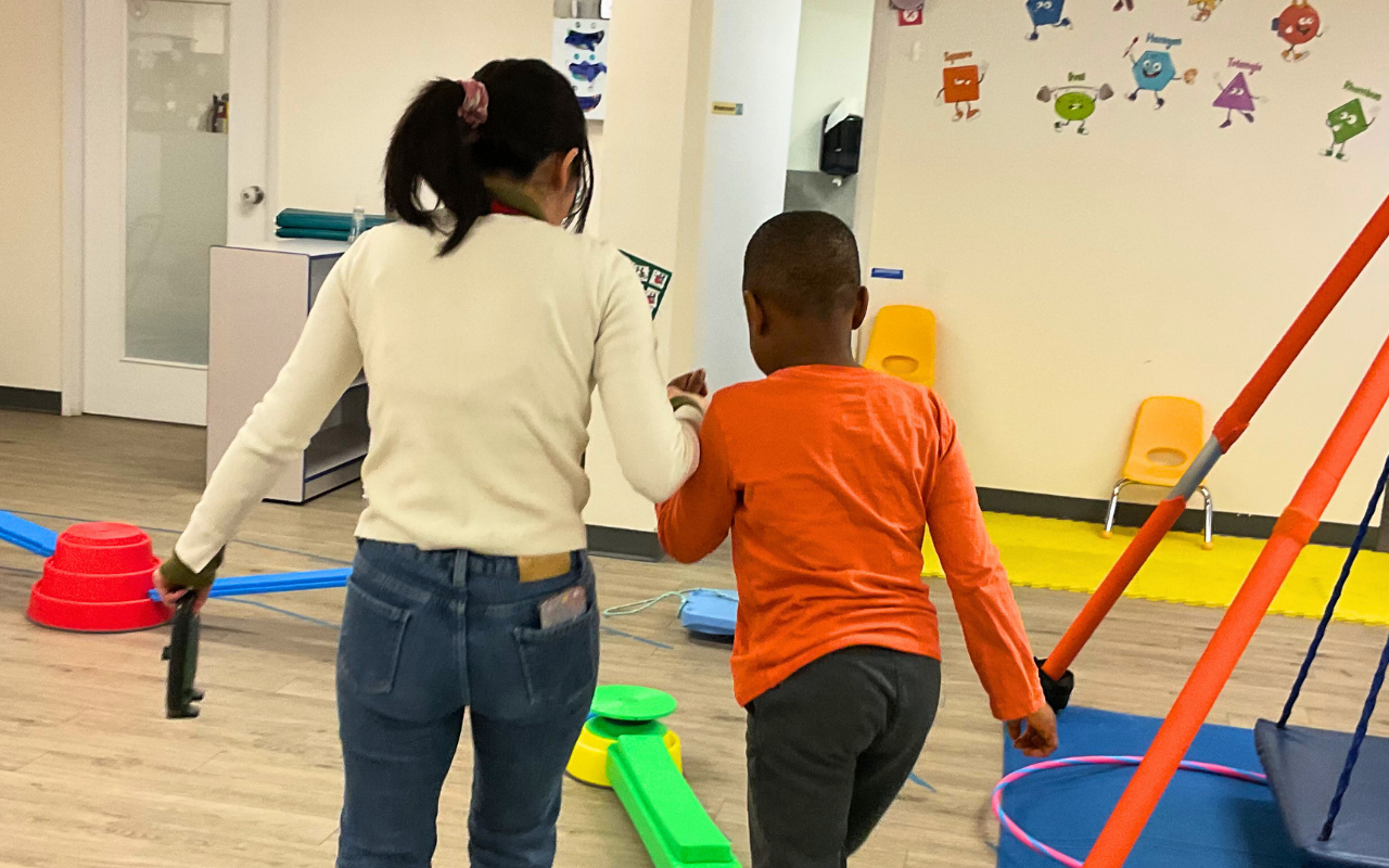 clinician and child in classroom playing