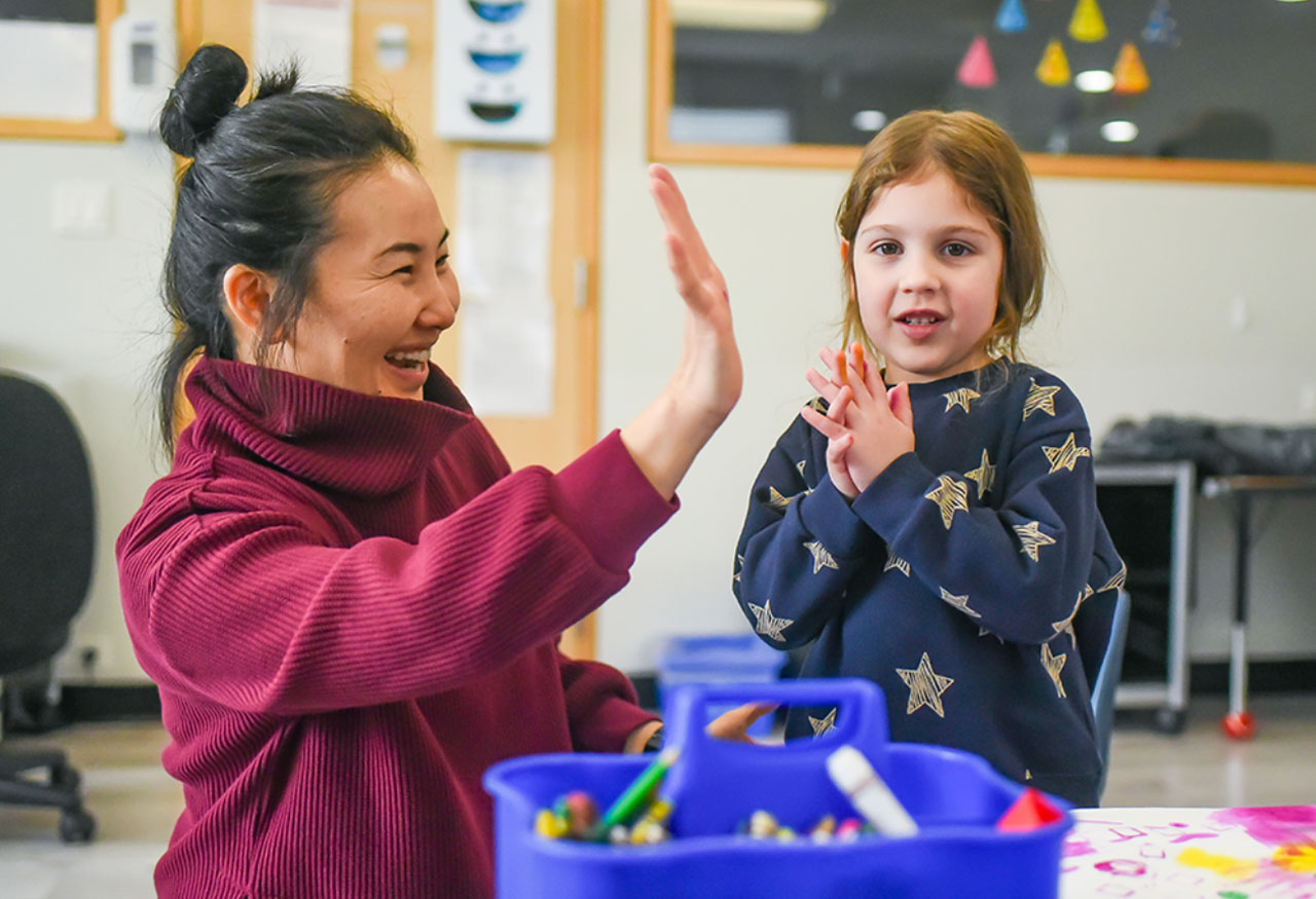 Staff high fiving young female client